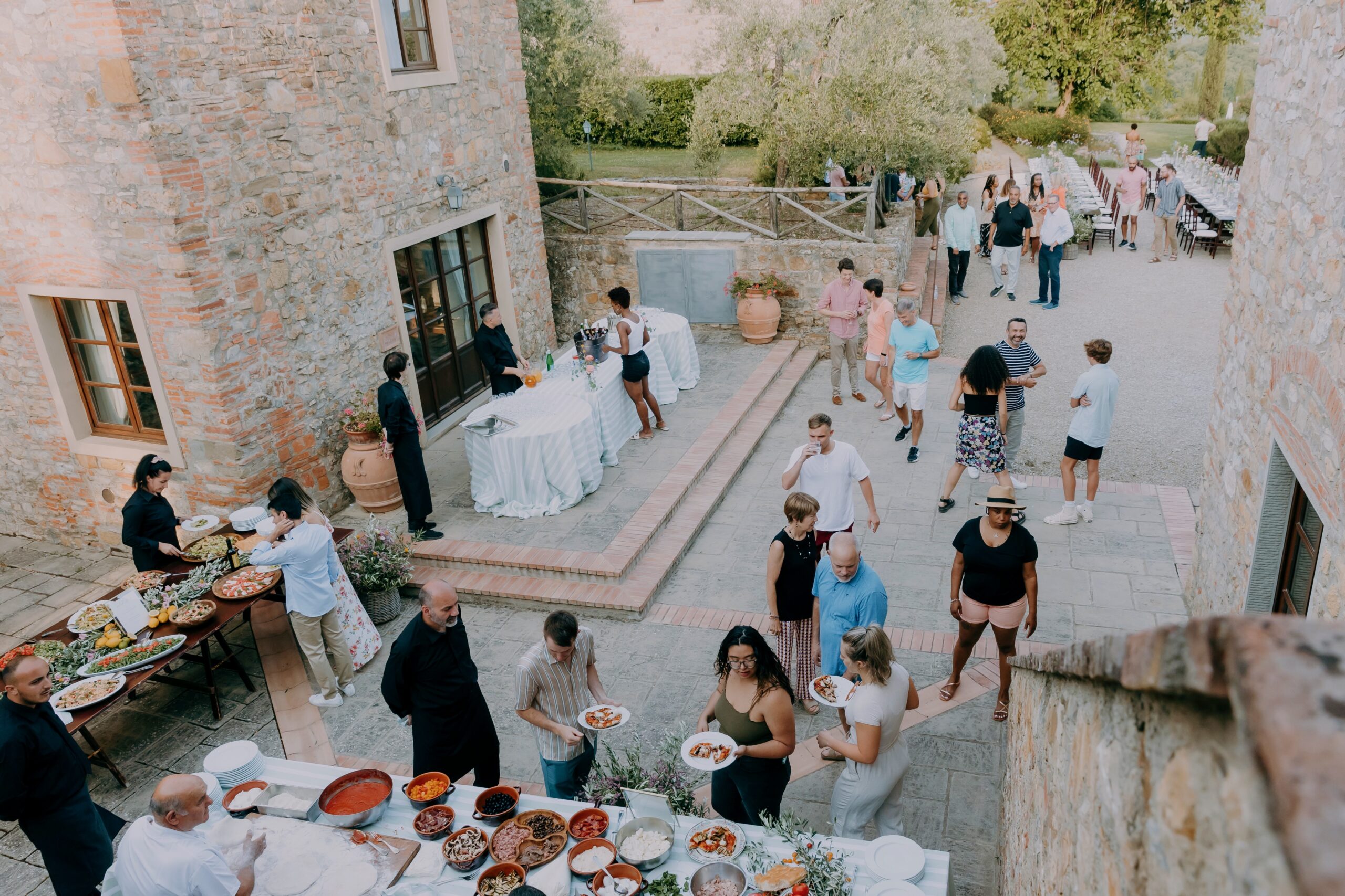 Guests enjoying a welcome pizza party before a destination wedding in Tuscany, Italy.