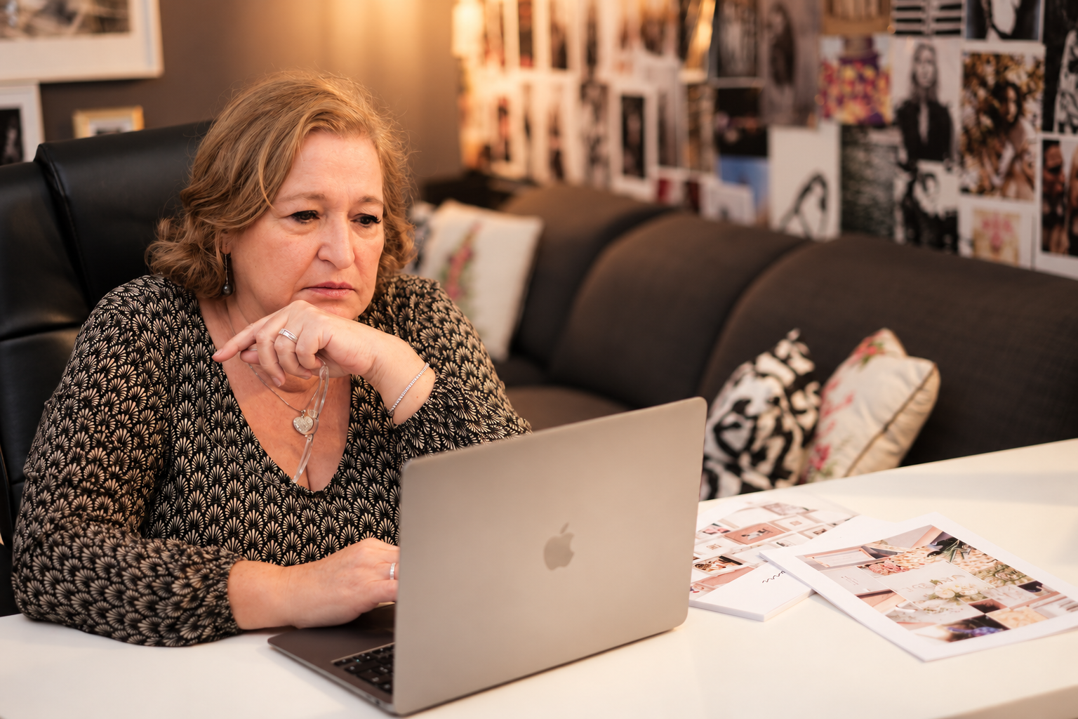 Daniela Ferrara at her desk with a laptop and wedding planning materials.